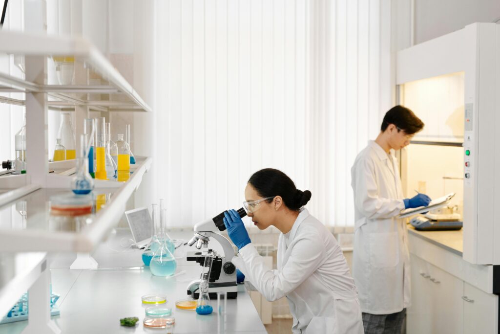 Two scientists working in a well-equipped laboratory with microscopes and test tubes.