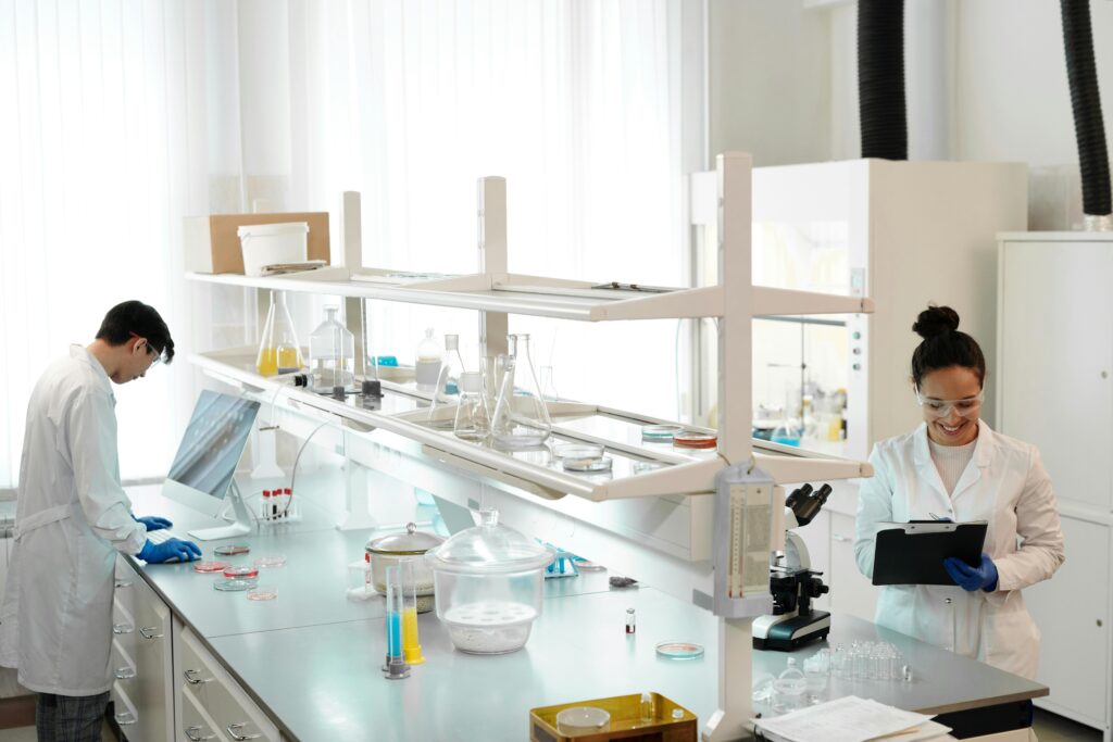 Two scientists working in a modern laboratory setting, analyzing and documenting experiments.
